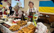 Team member serving borscht in traditional dress