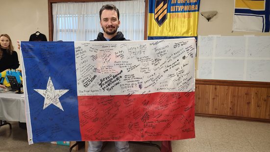 Guest holding a signed Texas flag